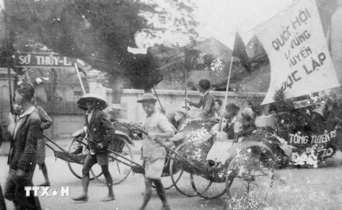 Thông qua các đoàn thể cứu quốc, Mặt trận Việt Minh đã tuyên truyền, vận động quần chúng tự nguyện và hăng hái tham gia các phong trào sản xuất, cứu đói, hũ gạo tiết kiệm, tuần lễ vàng, bình dân học vụ... nhằm phát huy tinh thần yêu nước của Nhân dân để vượt qua những khó khăn về kinh tế, tài chính. Trong ảnh: Nhân dân lao động Thủ đô cổ động cho ngày Tổng tuyển cử đầu tiên. (Ảnh: TTXVN)