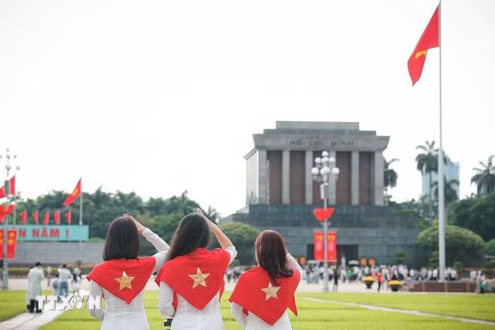 Nhiều bạn trẻ lựa chọn trang phục áo dài truyền thống khi tham quan và chụp ảnh tại khu vực Quảng trường Ba Đình, Lăng Chủ tịch Hồ Chí Minh. (Ảnh: Phạm Tuấn Anh/TTXVN)