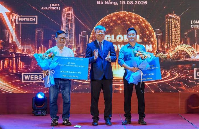 Anh Lê Ngọc Trí (bên trái), Giám đốc điều hành Công ty cổ phần EM&AI nhận hỗ trợ thiết thực từ Ủy ban nhân dân thành phố Đà Nẵng. (Ảnh: Thanh Phong/Vietnam+)