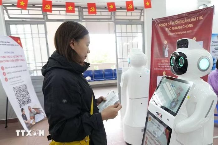 Người dân trao đổi với robot AI để được hướng dẫn thủ tục hành chính tại Trung tâm phục vụ hành chính công phường Xuân Hương, Đà Lạt (Lâm Đồng). (Ảnh: Nguyễn Dũng/TTXVN)