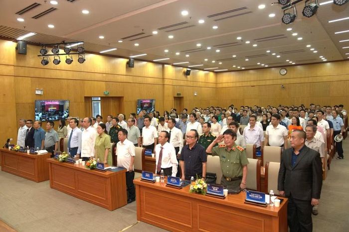 Các đại biểu, khách mời tham dự làm lễ chào cờ. (Ảnh: PV/Vietnam+)