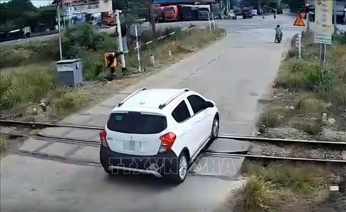 Ô tô con vượt gác chắn đường sắt khi gác chắn đang dịch chuyển tại xã Tuy An Bắc vào tháng 7/2026. Ảnh: TTXVN phát