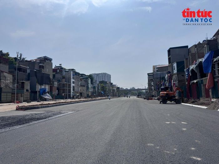Nhà thầu xây dựng đang tập trung thảm nhựa đoạn đường đã hoàn thành.