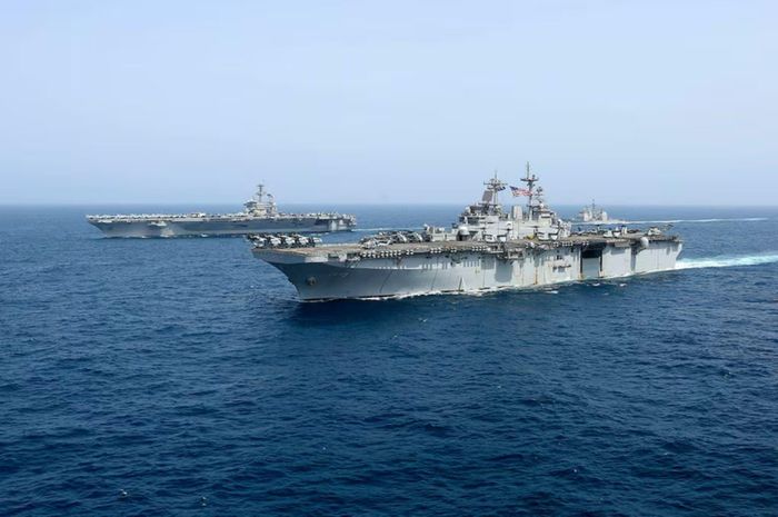 Tàu sân bay USS Abraham Lincoln (phía sau) của hải quân Mỹ di chuyển trên Biển Arab. Ảnh: AP/TTXVN