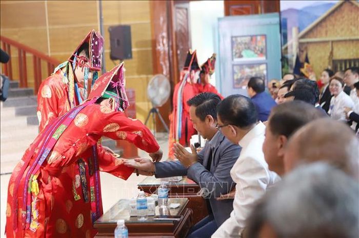 Nghi thức buộc chỉ cổ tay chúc may mắn của các nghệ sĩ Việt Nam cho khán giả Lào có sự đồng điệu với văn hóa Lào. Ảnh: Xuân Tú/PV TTXVN tại Lào