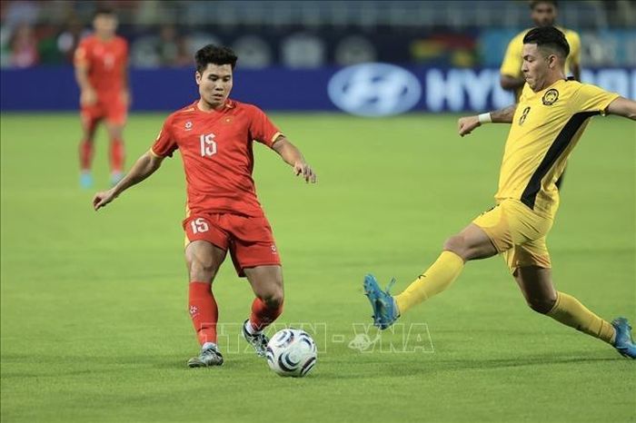 Pha vào bóng của hậu vệ bên phía Malaysia. Ảnh: Minh Quyết/TTXVN