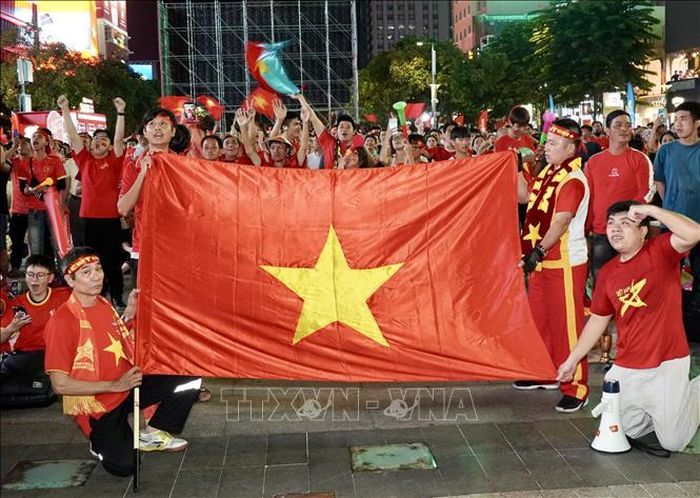 Người hâm mộ mang theo cờ Tổ quốc hòa chung không khí cổ vũ đội tuyển Việt Nam trong trận bán kết lượt về ASEAN Hyundai Cup 2026 tại phố đi bộ Nguyễn Huệ. Ảnh: Trung Tuyến/TTXVN