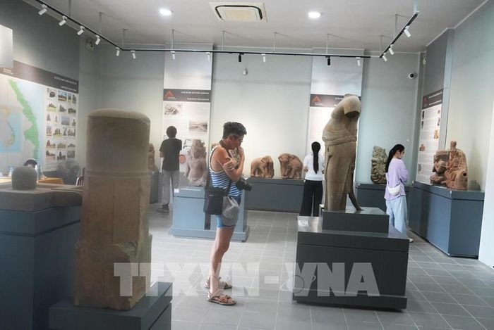 Du khách quốc tế tham quan, tìm hiểu Khu trưng bày cổ vật Chăm trong Kinh thành Huế, thành phố Huế. Ảnh: Nguyên Lý - TTXVN