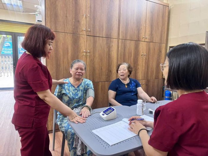 Nhân viên y tế đo huyết áp cho người cao tuổi tại phường Đống Đa.