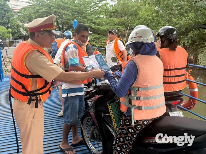 Cán bộ chiến sỹ đang hướng dẫn người dân về đảm bảo an toàn khi lưu thông trong mùa mưa bão.