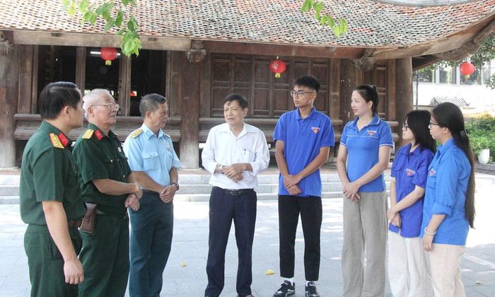 Bậc cao niên kể chuyện lịch sử, truyền thống cách mạng cho thanh niên dưới mái đình Đình Bảng.