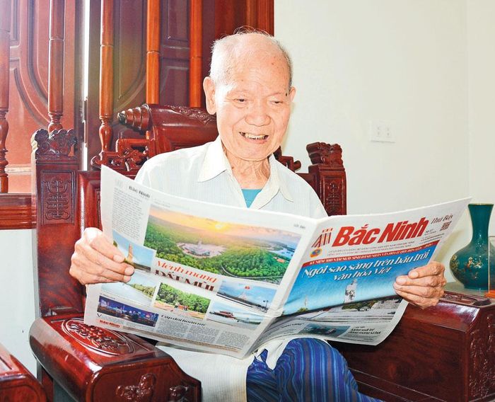 Anh hùng Lực lượng vũ trang nhân dân Nguyễn Văn Vượng đọc báo nắm bắt tình hình thời sự.