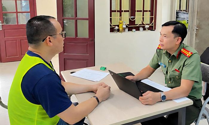 Trung tá Bùi Hữu Hợp (bên phải) thẩm vấn đối tượng cầm đầu đường dây tổ chức đánh bạc xuyên quốc gia quy mô lớn.