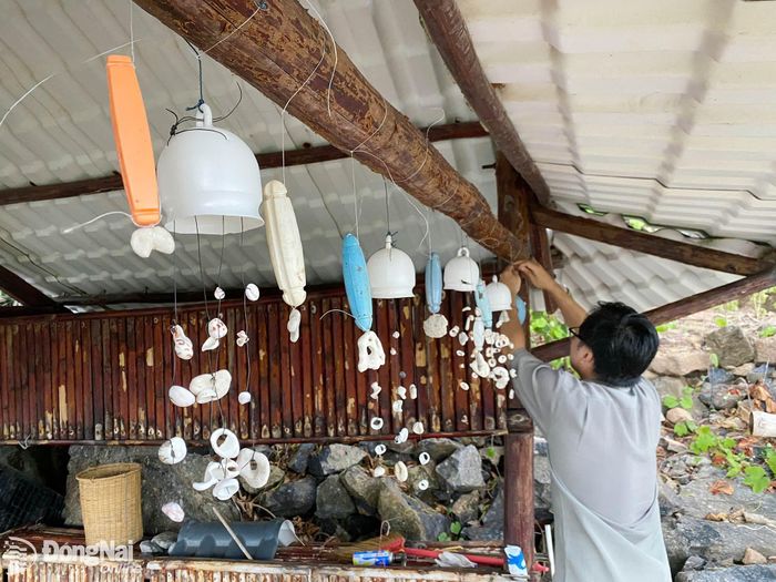 Các tình nguyện viên làm đồ thủ công từ vỏ sò để trang trí cho trạm kiểm lâm trên đảo Hòn Tre Lớn. Ảnh: NVCC