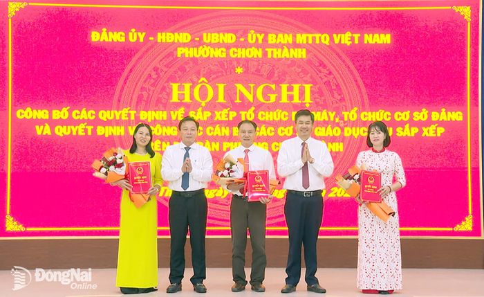 Lãnh đạo phường Chơn Thành trao quyết định và tặng hoa chúc mừng Ban giám hiệu Trường tiểu học và THCS Lương Thế Vinh. Ảnh: Đỗ Trình