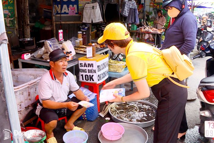 Nhân viên Bưu điện thành phố Đồng Nai tuyên truyền lợi ích khi tham gia bảo hiểm xã hội, bảo hiểm y tế đến người dân. Ảnh: Hạnh Dung