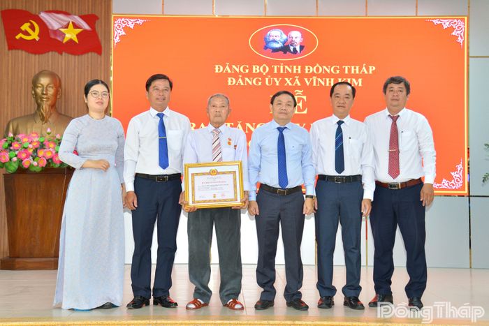 Lãnh đạo tỉnh Đồng Tháp và lãnh đạo xã Vĩnh Kim chụp ảnh lưu niệm tại lễ trao Huy hiệu 70 năm tuổi Đảng cho đồng chí Đoàn Hiếu Thảo.