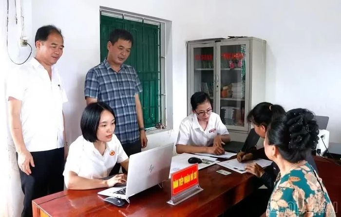 Cán bộ Trung tâm Phục vụ hành chính công xã Quy Mông giải quyết thủ tục hành chính lưu động. (Ảnh: Hồng Oanh)