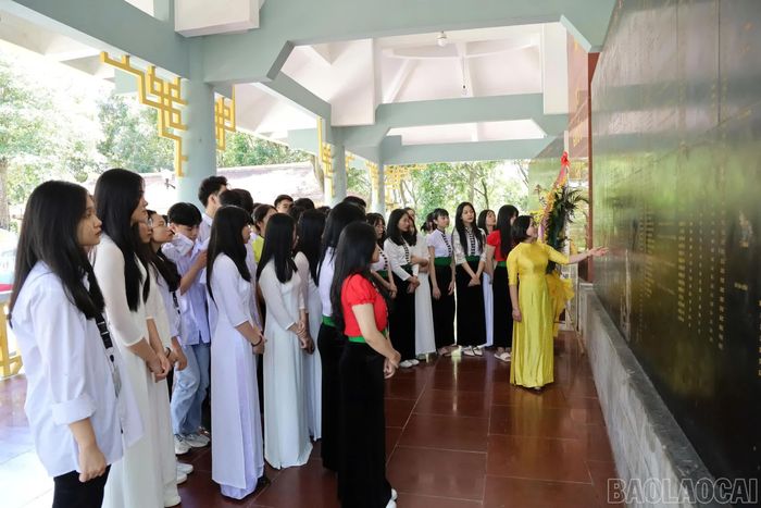 Học sinh Trường THPT Nghĩa Lộ trước nhà bia ghi danh các anh hùng liệt sĩ tại Khu di tích lịch sử - văn hoá Căng và Đồn Nghĩa Lộ.