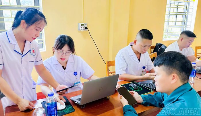 Cán bộ Trạm Y tế xã Tân Hợp hỗ trợ người dân cập nhật Sổ sức khỏe điện tử.