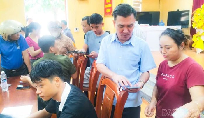 Đồng chí Khổng Giang Lam - Bí thư Đảng uỷ, Chủ tịch HĐND xã trực tiếp hướng dẫn người dân sử dụng ứng dụng VNeID.