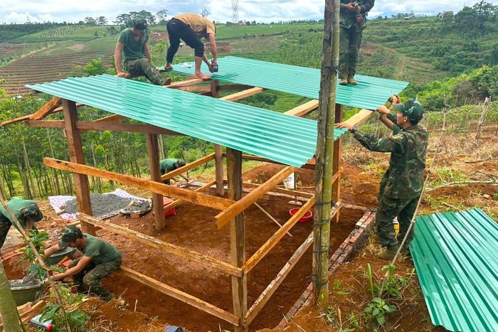 Cán bộ, chiến sĩ Trung đoàn 994A hỗ trợ gia đình anh Lý Văn Duy xây dựng chuồng trại, sửa chữa nhà.