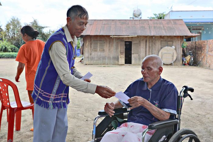 Già làng Kră Jăn Nhang tới từng hộ dân trong thôn phát thẻ cử tri cho bà con thôn Đam Pao tại Ngày hội bầu cử ĐBQH và HĐND các cấp vào tháng 3/2026