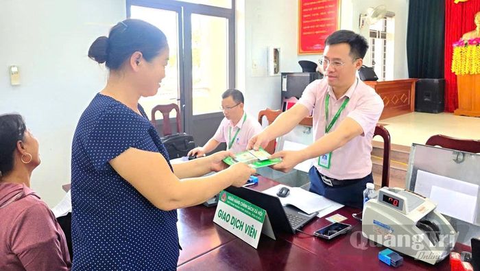 Cán bộ Phòng Giao dịch Ngân hàng Chính sách xã hội Quảng Trạch giải ngân vốn vay cho người dân tại điểm giao dịch xã Phú Trạch - Ảnh: M.L
