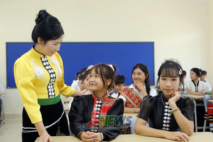 Cô giáo đón học sinh nhập học.