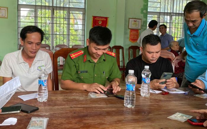Cán bộ Công an xã Núi Thành hỗ trợ, hướng dẫn người dân chuyển đổi số.