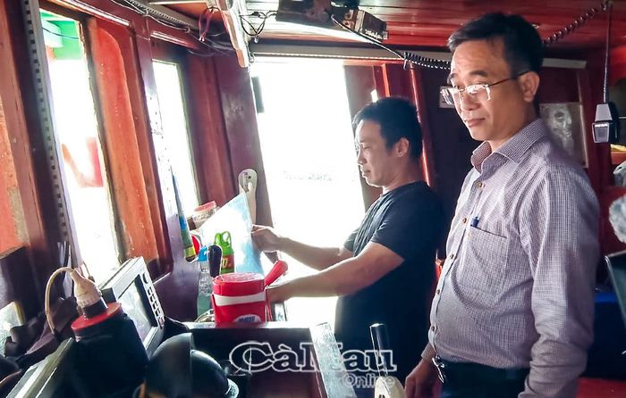 Ông Phạm Văn Mười, Phó Giám đốc Sở Nông nghiệp và Môi trường tỉnh Cà Mau kiểm tra thiết bị giám sát hành trình của tàu cá tại Cảng cá Sông Ðốc.
