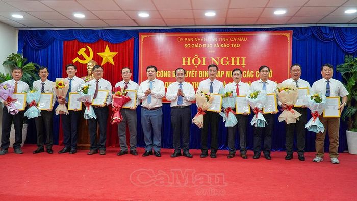 Đồng chí Nguyễn Minh Luân (thứ 6 từ phải sang), Phó Chủ tịch UBND tỉnh và Giám đốc Sở GD&ĐT Nguyễn Văn Nguyên (thứ 6 từ trái sang), trao quyết định sáp nhập các cơ sở giáo dục.