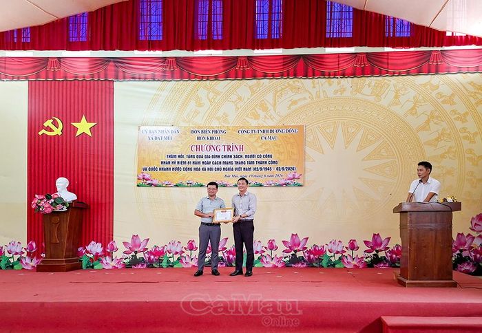 Đồng chí Đỗ Trọng Nghĩa, Phó Chủ tịch UBND xã Đất Mũi (bên phải), trao thư cảm ơn mạnh thường quân.