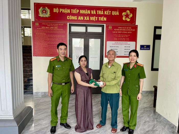Chị Duyên trao trả lại tài sản cho ông Khải trước sự chứng kiến của cán bộ, chiến sĩ Công an xã Việt Tiến. Ảnh: CA. ↵