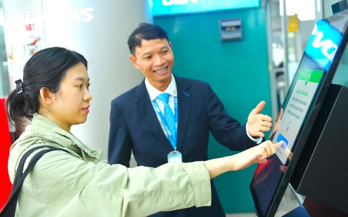 Hành khách được nhân viên sân bay hướng dẫn làm thủ tục trước khi bay bằng hệ thống máy móc hiện đại.