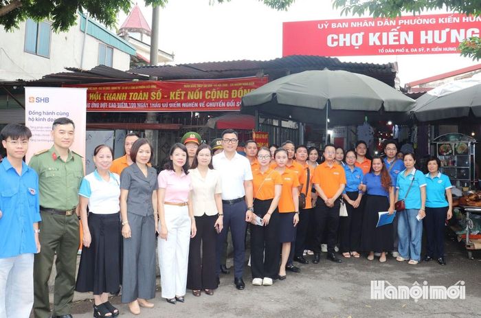 Các thành viên đội hình chuyển đổi số đến chợ Kiến Hưng hỗ trợ người dân thực hiện giao dịch không dùng tiền mặt. Ảnh: Tuấn Điệp