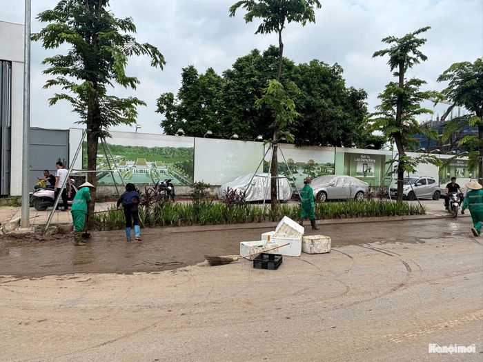 Thu gom vật liệu, vệ sinh môi trường khu vực dự án đường Vành đai 2,5 đoạn từ đường Nguyễn Trãi đến Đầm Hồng. Ảnh: HT