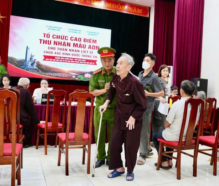 Công an xã Hồng Vân hỗ trợ thân nhân liệt sĩ là người cao tuổi. Ảnh: Vũ Hậu.