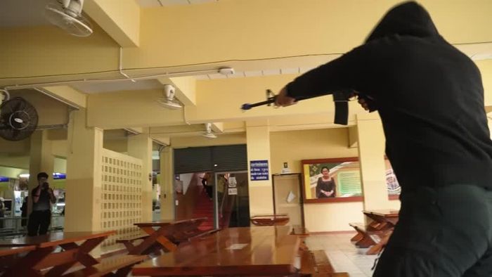 Một sĩ quan cảnh sát hoá trang, sử dụng súng trong buổi diễn tập. Ảnh: Reuters