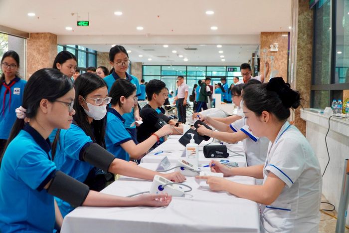 Nhân viên y tế kiểm tra huyết áp cho các em học sinh. Ảnh: Tiến Đạt.