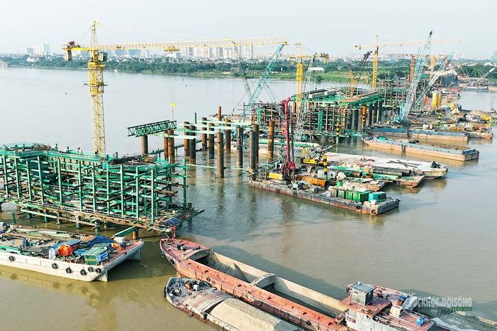 Công trường thi công cầu chính giữa sông Hồng với nhiều sà lan, cần cẩu và thiết bị chuyên dụng. Ảnh: Tuấn Anh