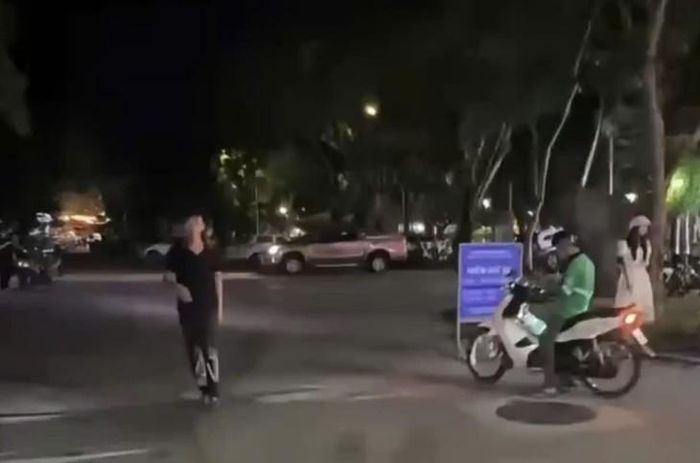 Nam thanh niên mặc áo đen đi ra từ khu vực bãi giữ xe ô tô thuộc quản lý của Trung tâm Công viên cây xanh Huế . Ảnh chụp màn hình từ clip.
