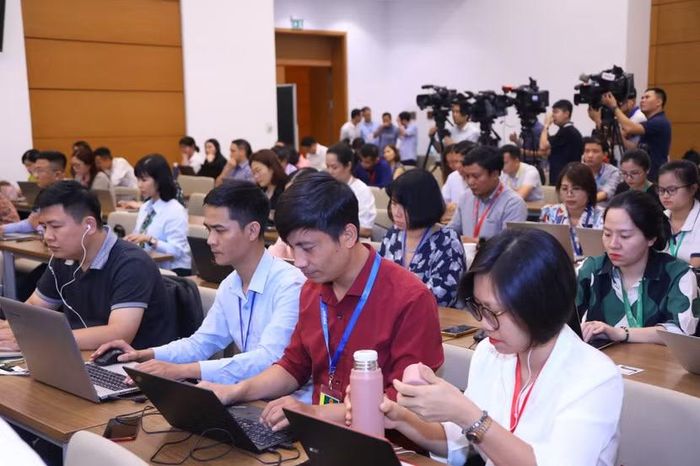 Tác giả (ở giữa) tác nghiệp ở Trung tâm Báo chí Quốc hội tại một kỳ họp của Quốc hội khóa XV