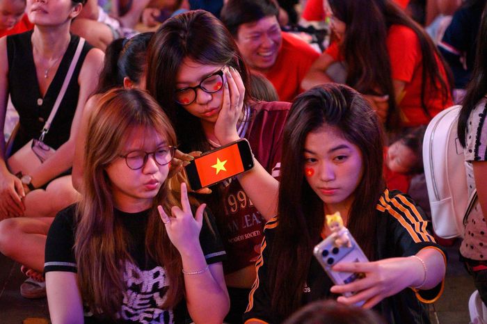  Nhiều người tranh thủ check-in giữa biển người tại phố đi bộ Nguyễn Huệ trước giờ bóng lăn. Sắc đỏ của áo, cờ và không khí cổ vũ khiến khoảnh khắc chờ trận đấu càng thêm đặc biệt. 