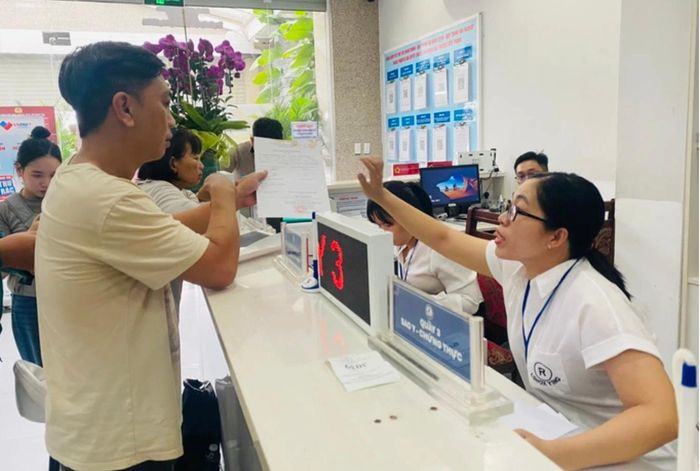 Công chức TP.HCM hướng dẫn thủ tục hành chính cho người dân. Ảnh: Phan Anh.