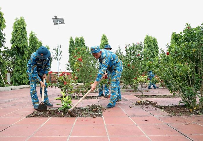 Các chiến sĩ của Trung đoàn 260 dọn dẹp, làm vệ sinh trong khu vực Nghĩa trang Liệt sĩ xã Đan Phượng
