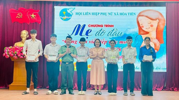 Lãnh đạo xã Hòa Tiến và các "mẹ đỡ đầu" tặng quà cho các em học sinh.