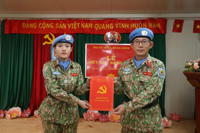  Thiếu tá Nguyễn Đức Trọng trao quyết định kết nạp Đảng cho Đại úy QNCN Đặng Thị Thanh Phượng. Ảnh: GGHBVN 