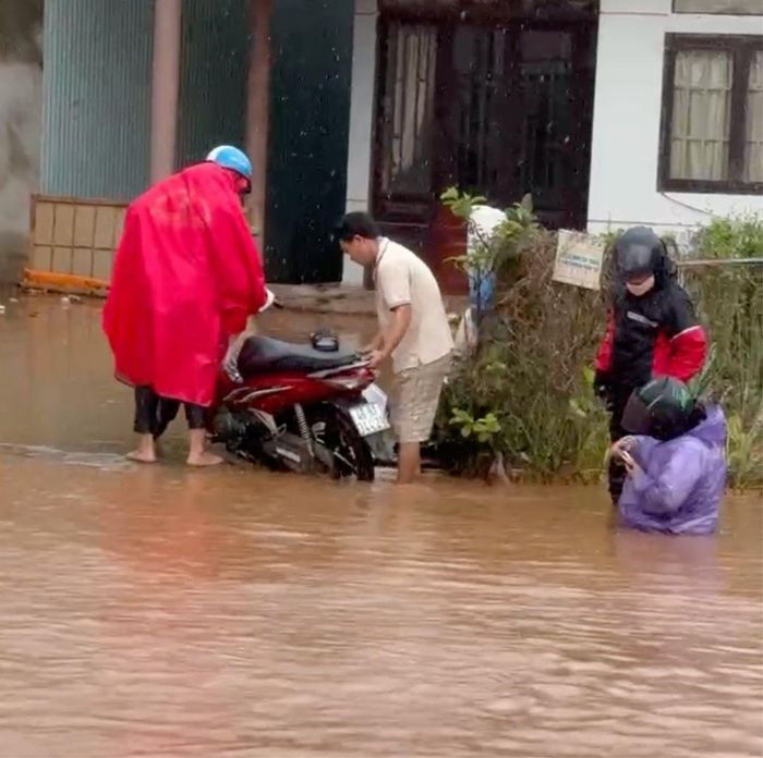 Người dân vất vả lưu thông qua đoạn bị ngập trên quốc lộ 55