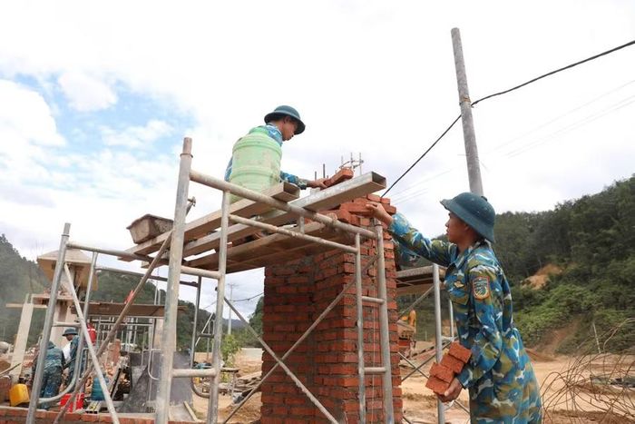Cán bộ, chiến sĩ Sư đoàn Phòng không 375 hỗ trợ xây tường rào.